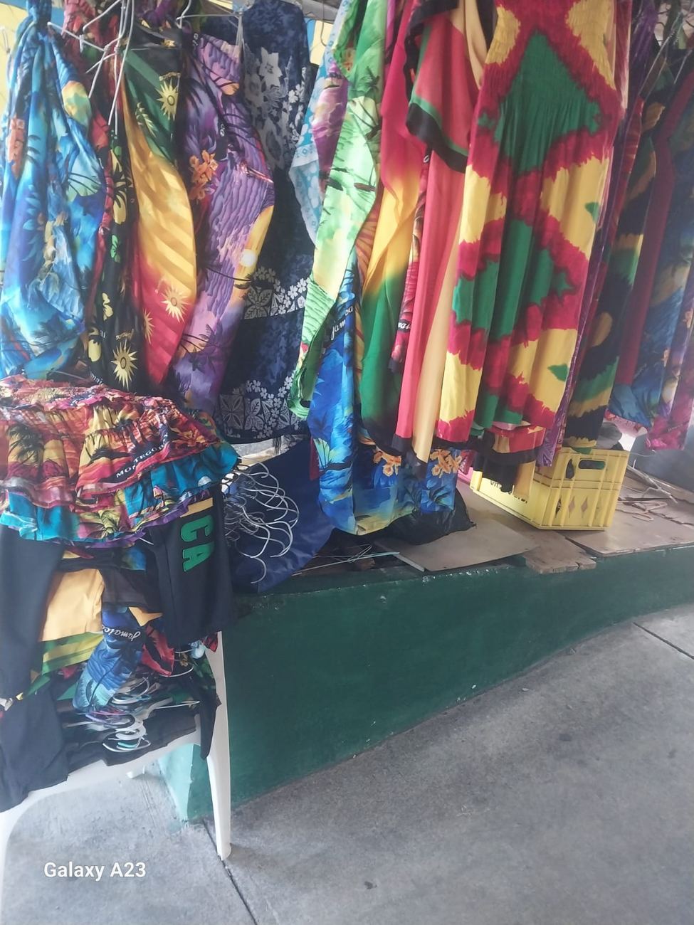 Rack of colourful Jamaican-print dresses and resort wear